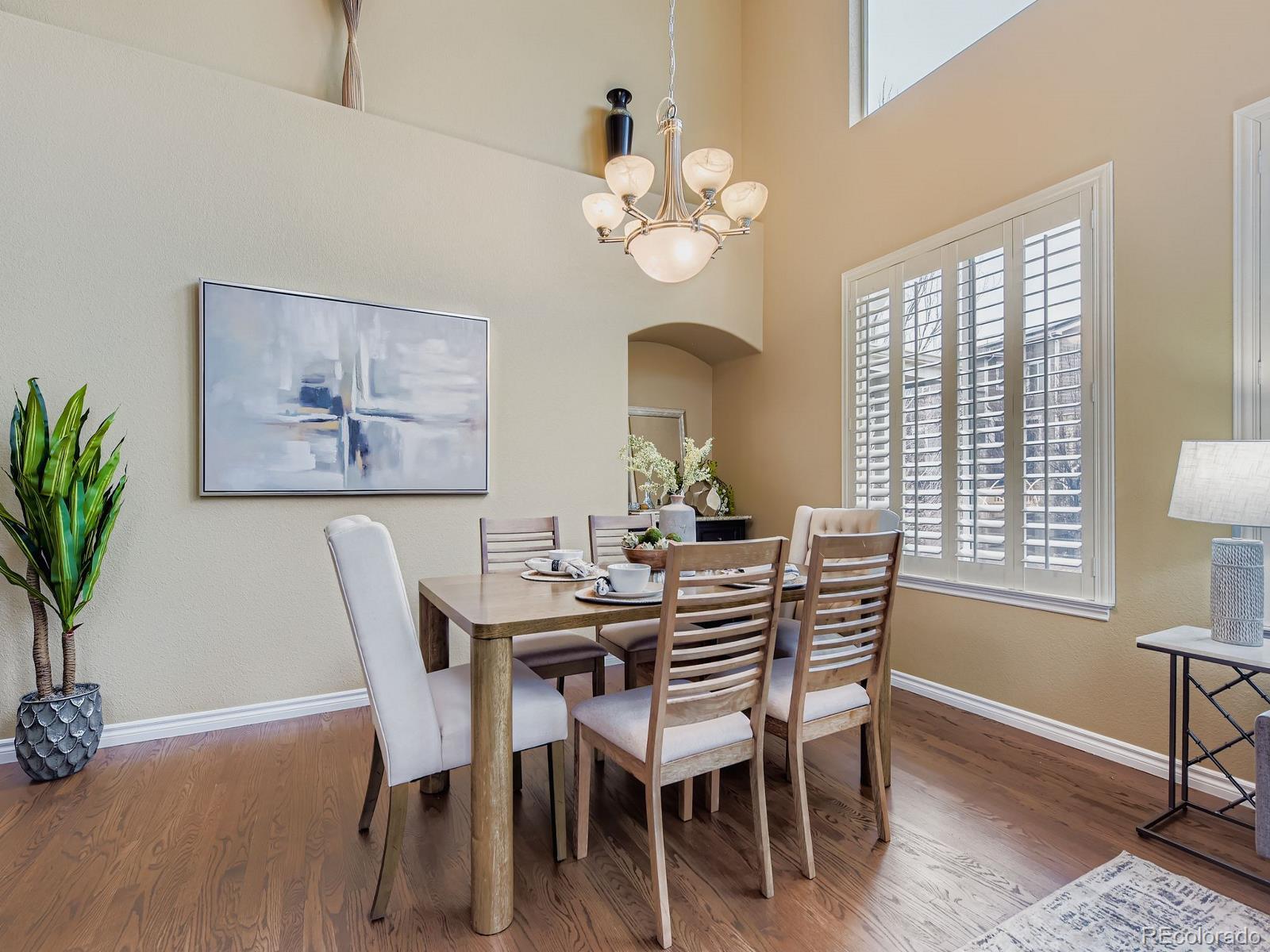 11074 Grayledge Circle Highlands Ranch, CO 80130 - Photo 8 of 47 a dining room with wooden floor a chandelier a wooden table and chairs