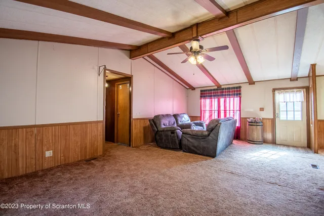 a living room with furniture a chandelier and a dining table
