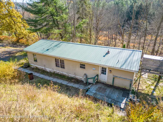 a roof deck with table and chairs and potted plants
