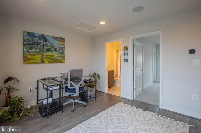 a view of a workspace room with furniture and wooden floor