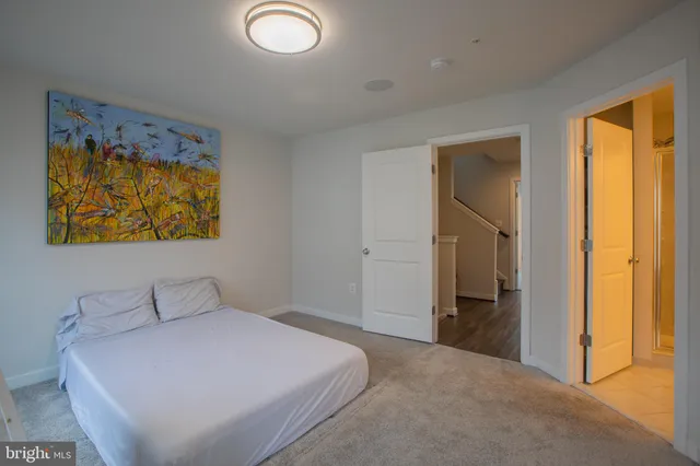 a bedroom with a bed and a painting on the wall