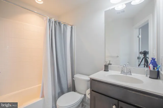 a bathroom with a sink a toilet and shower curtain