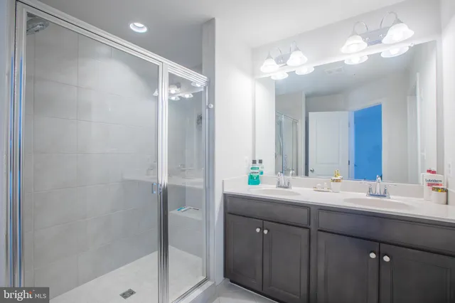 a bathroom with a double vanity sink mirror and shower