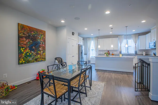 a kitchen with a dining table chairs and refrigerator