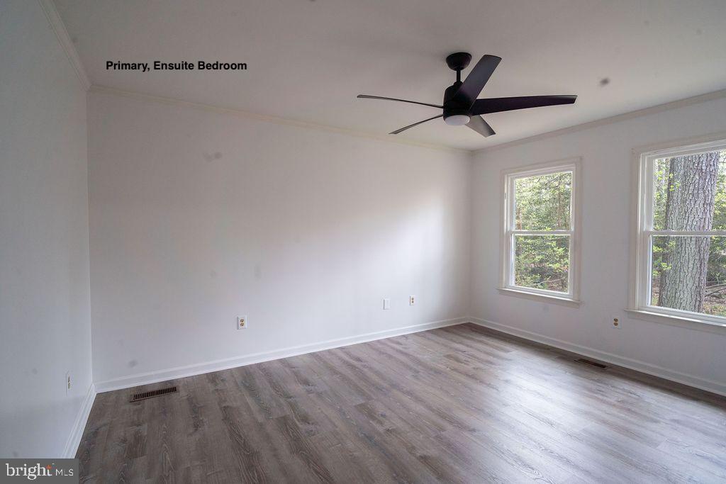 89 Club View Drive Lancaster, VA 22503 - Photo 11 of 25 an empty room with wooden floor fan and windows