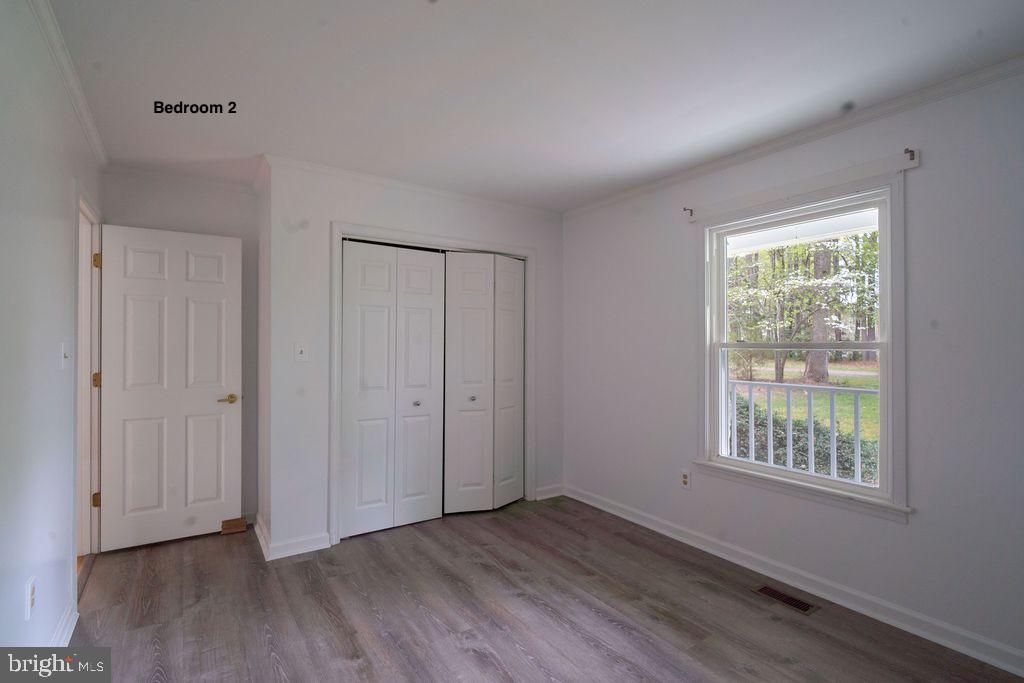 89 Club View Drive Lancaster, VA 22503 - Photo 14 of 25 a view of an empty room with wooden floor and a window