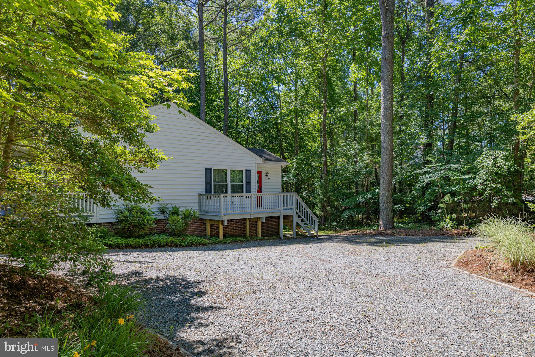89 Club View Drive Lancaster, VA 22503 - Photo 4 of 25 a front view of a house with a yard and trees