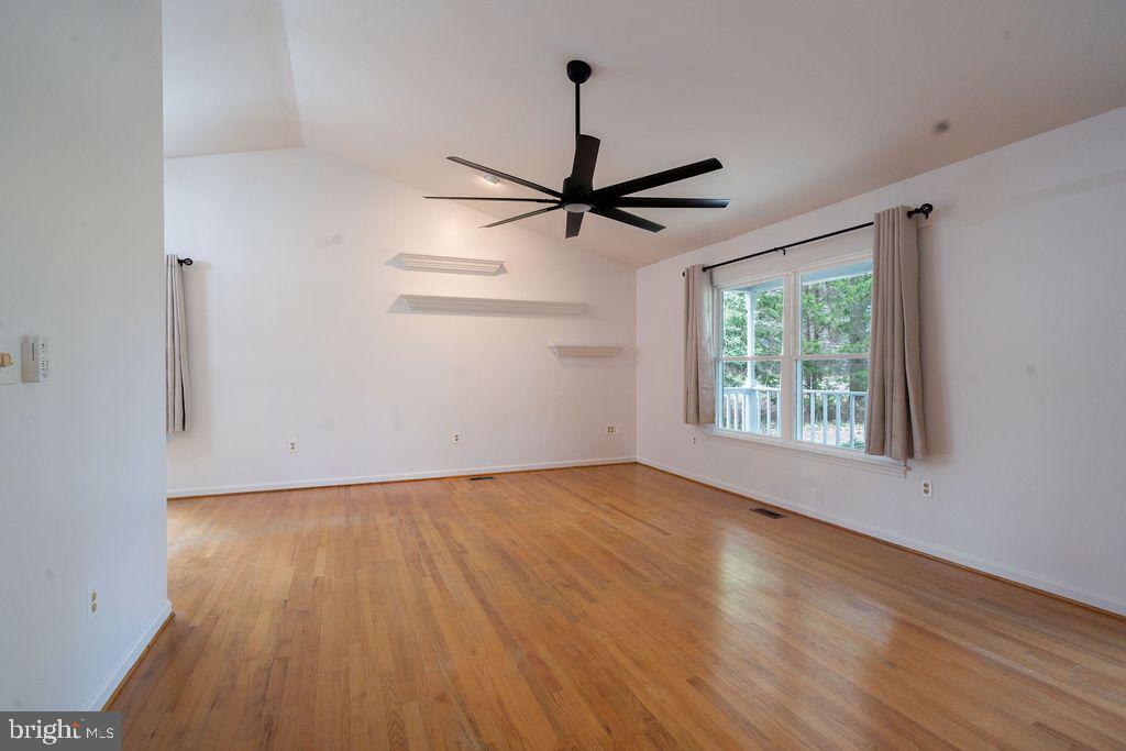 89 Club View Drive Lancaster, VA 22503 - Photo 7 of 25 an empty room with wooden floor ceiling fan and windows