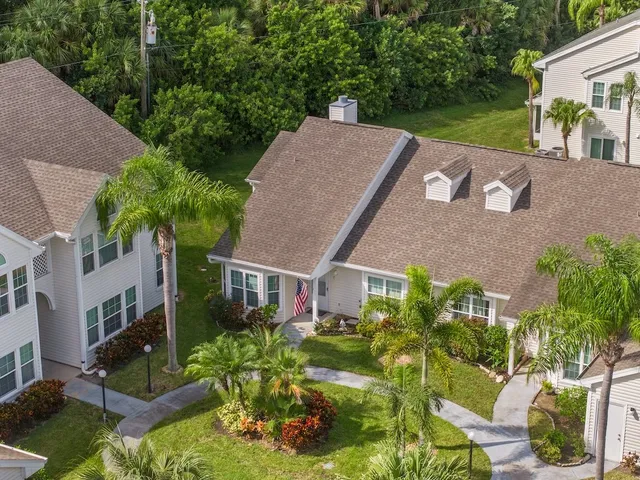 a view of a house with a yard and potted plants