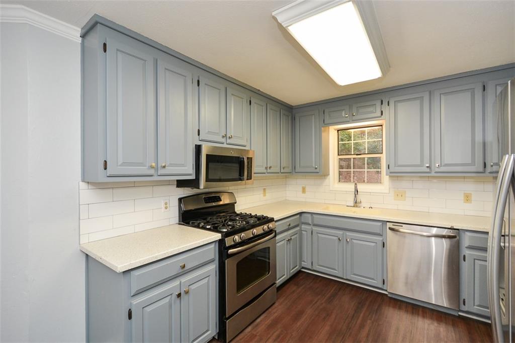 1413 Reed Lane Woodstock, GA 30189 - Photo 14 of 68 a kitchen with a sink stove and microwave