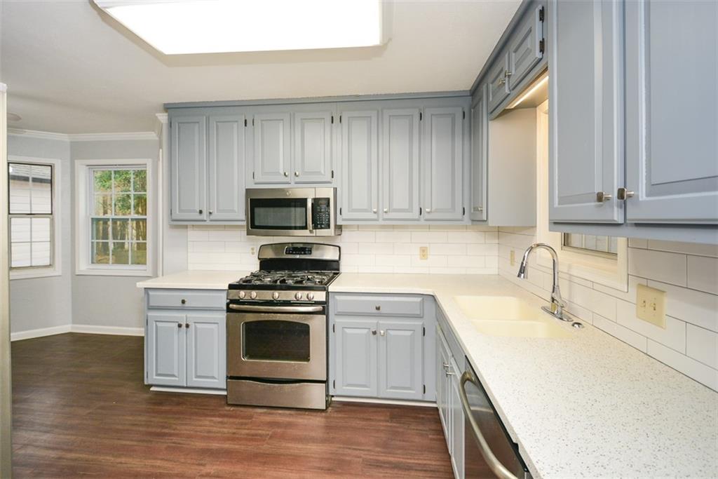 1413 Reed Lane Woodstock, GA 30189 - Photo 16 of 68 a kitchen with a stove a sink and a microwave