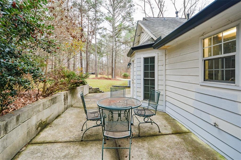 1413 Reed Lane Woodstock, GA 30189 - Photo 44 of 68 a view of a patio with table and chairs with wooden floor and fence