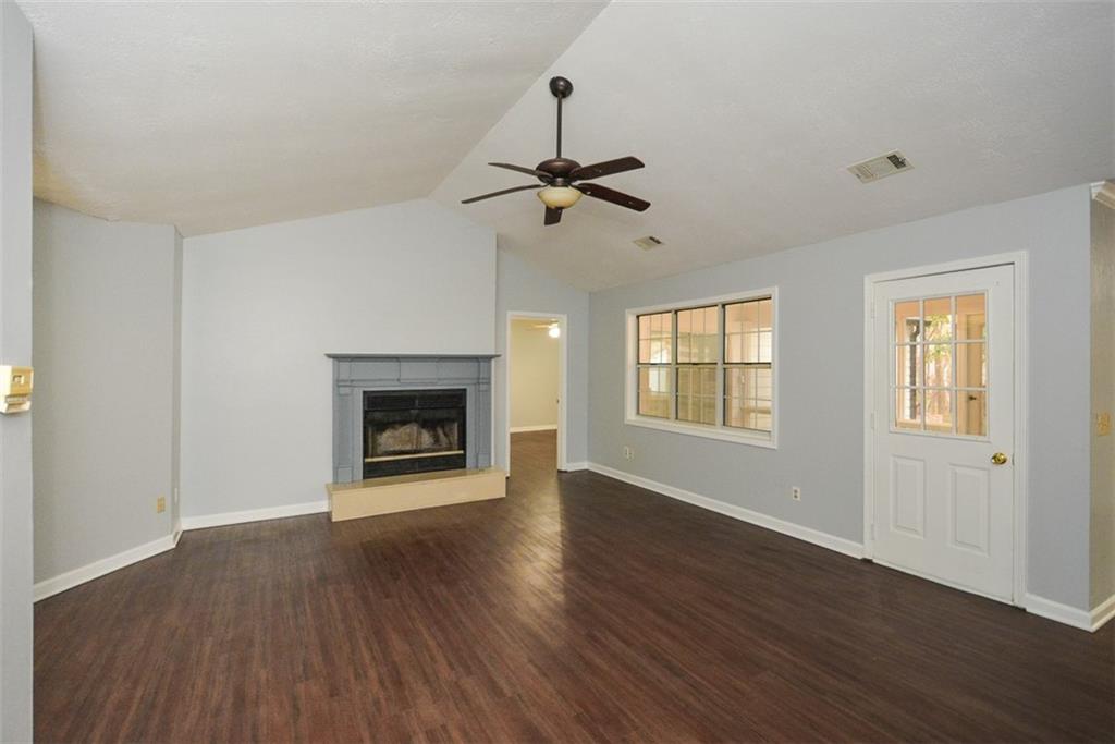 1413 Reed Lane Woodstock, GA 30189 - Photo 7 of 68 a view of an empty room with wooden floor fireplace and a window