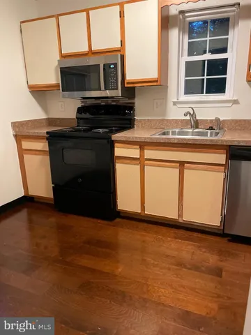 a kitchen with white cabinets and sink