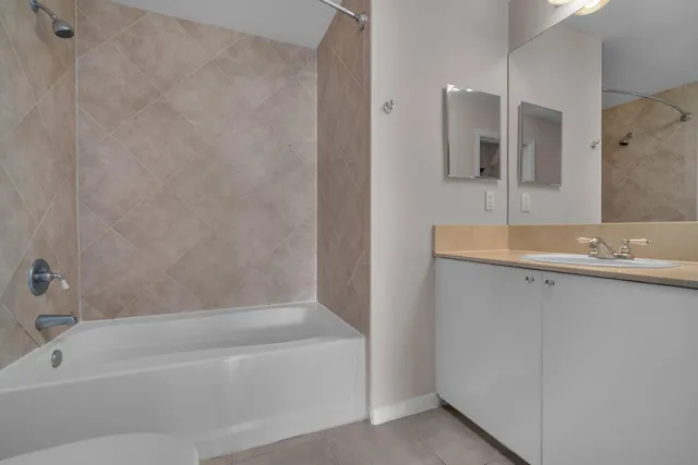 a bathroom with a granite countertop bathtub shower sink and mirror