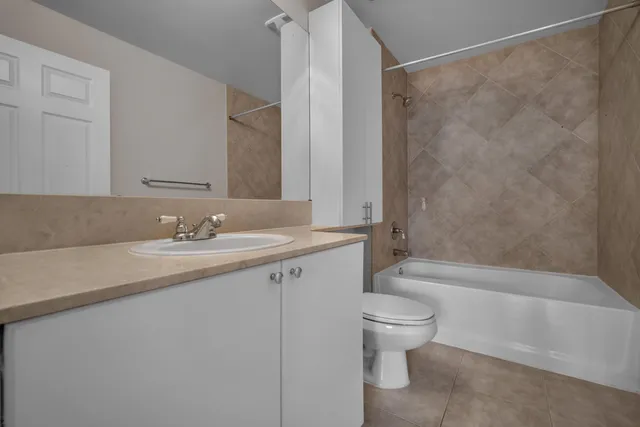 a bathroom with a granite countertop sink a toilet and shower