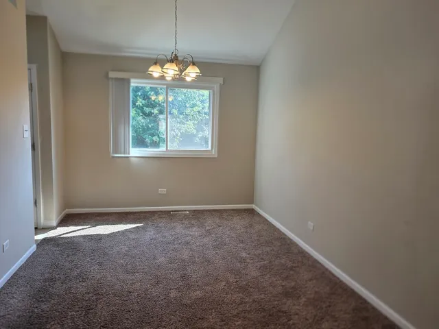 an empty room with windows and chandelier