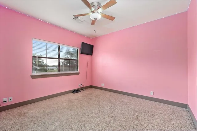 a view of a big room with window and ceiling fan