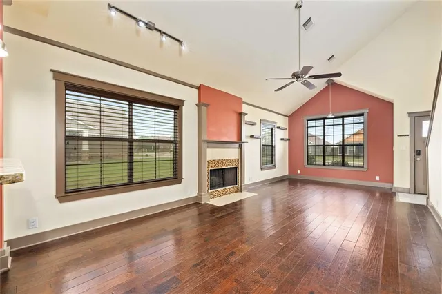 a view of a room with wooden floor fireplace and windows
