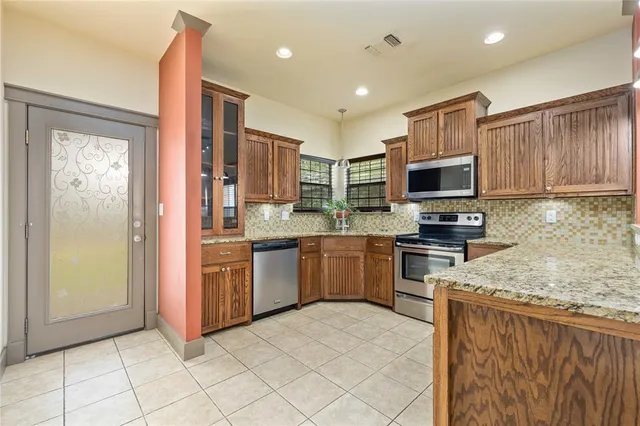 a kitchen with stainless steel appliances granite countertop a refrigerator and microwave