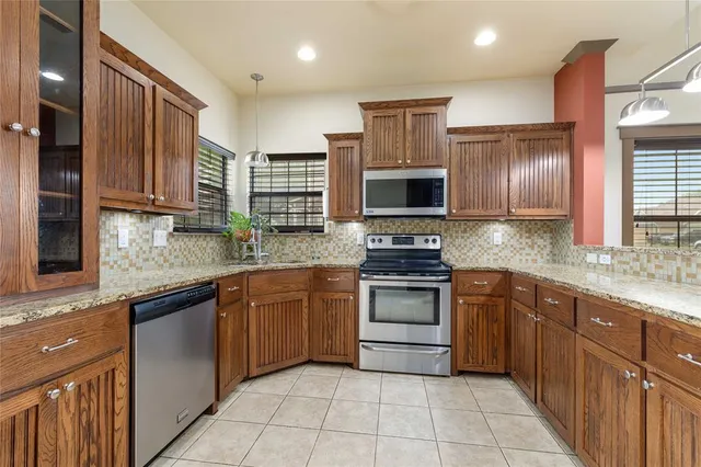 a kitchen with stainless steel appliances granite countertop a stove sink and cabinets