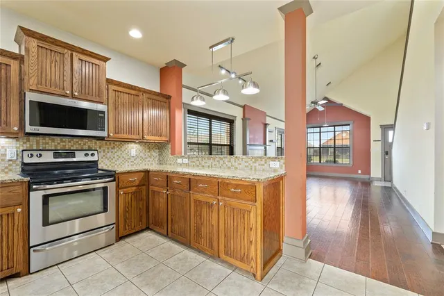 a kitchen with stainless steel appliances granite countertop a stove a sink and a microwave