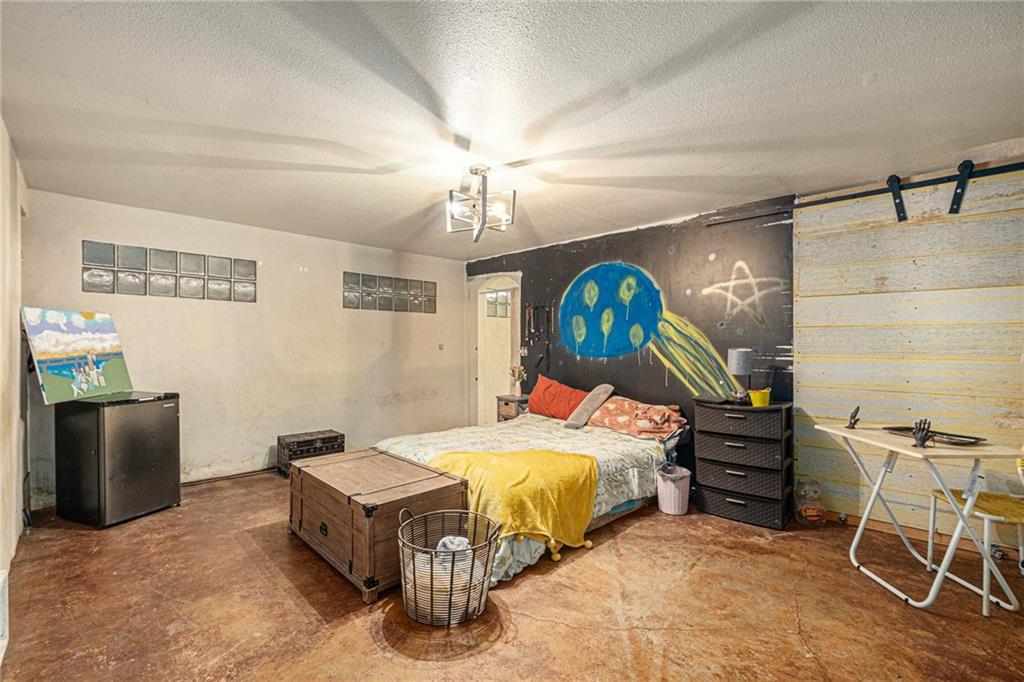 880 Golf Course Road Demorest, GA 30535 - Photo 26 of 37 a bedroom with a bed and a chandelier