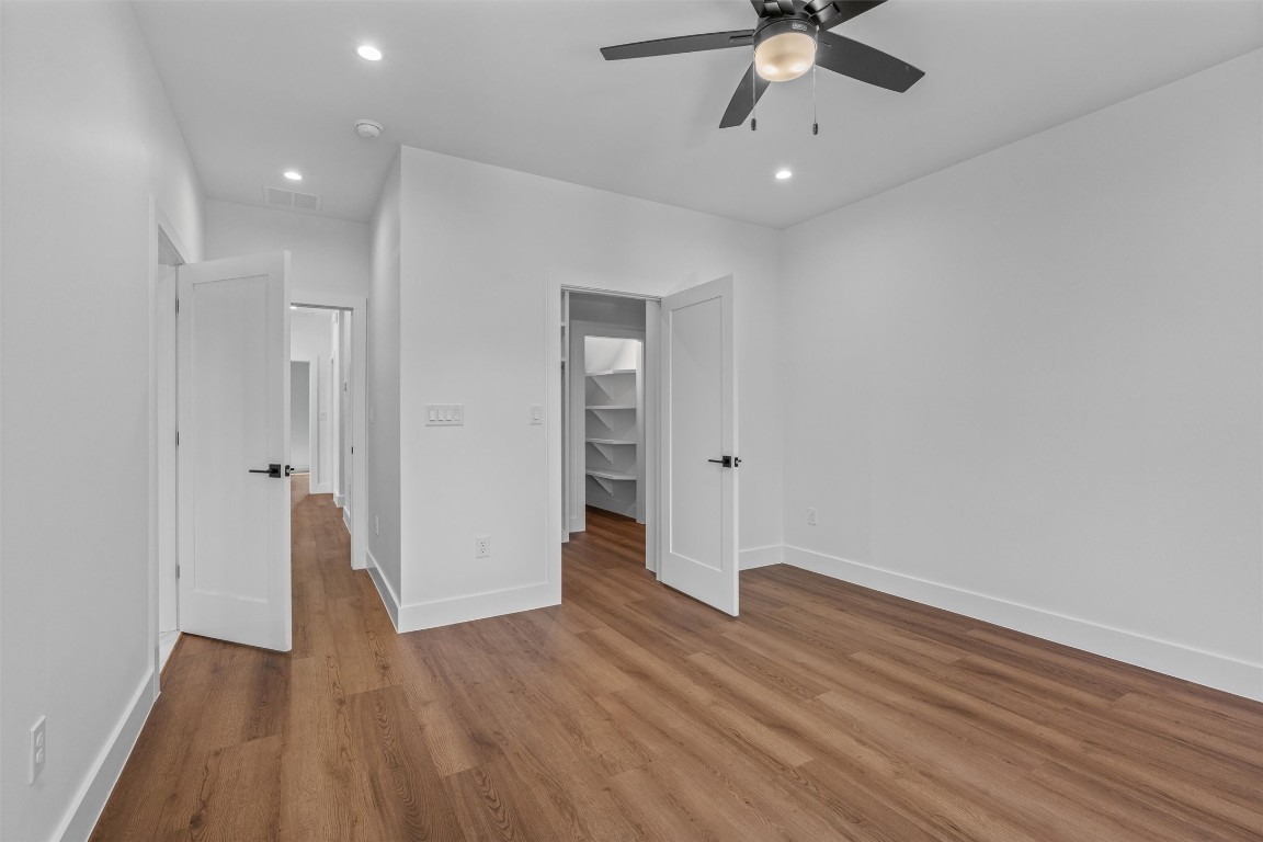 1402 Beckett Street, Unit 1B Austin, TX 78757 - Photo 11 of 32 an empty room with wooden floor and ceiling fan
