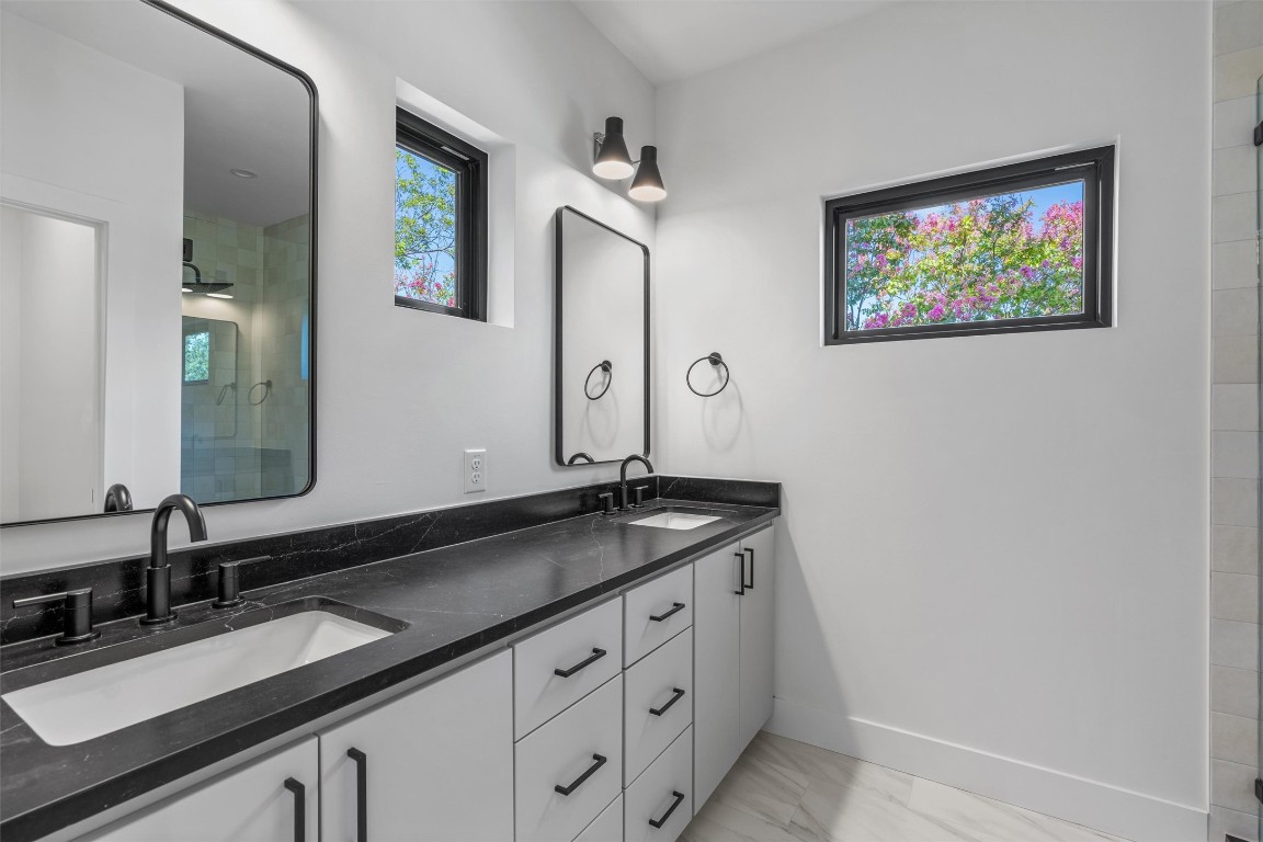1402 Beckett Street, Unit 1B Austin, TX 78757 - Photo 14 of 32 a bathroom with a granite countertop double vanity sink and a mirror