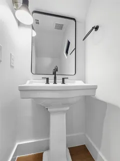 an empty room with wooden floor and a toilet