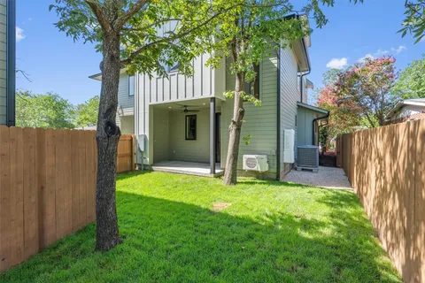a view of backyard with wooden fence and a large tree