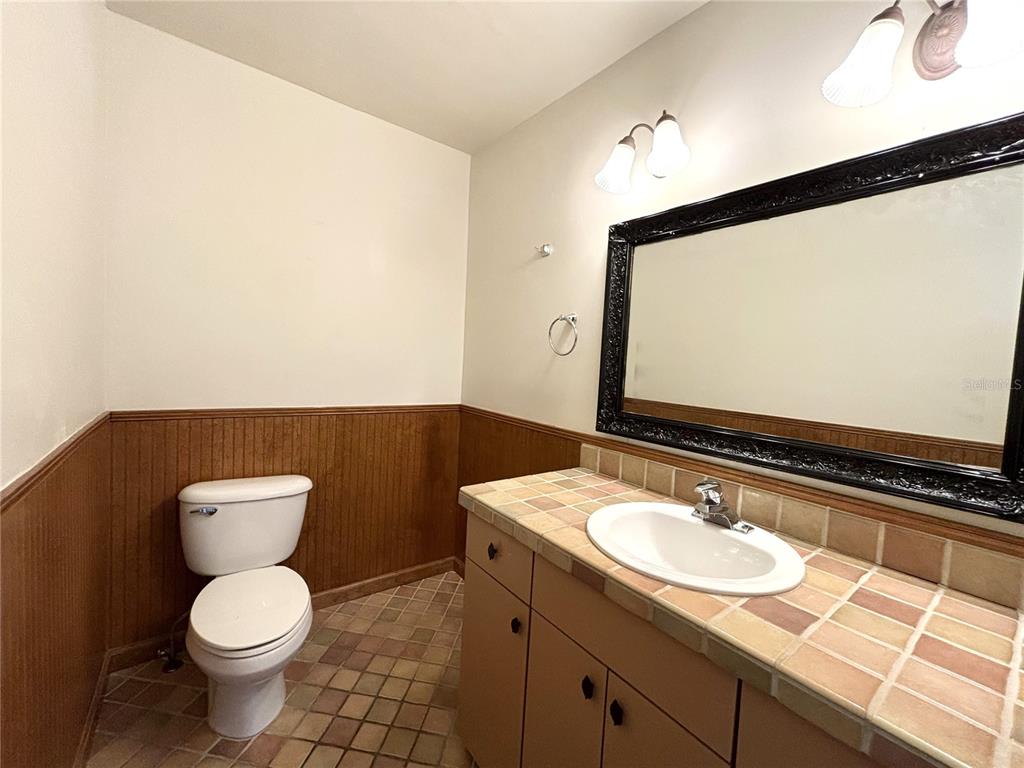 2350 26th Street North St. Petersburg, FL 33713 - Photo 9 of 18 a bathroom with a granite countertop sink toilet and mirror