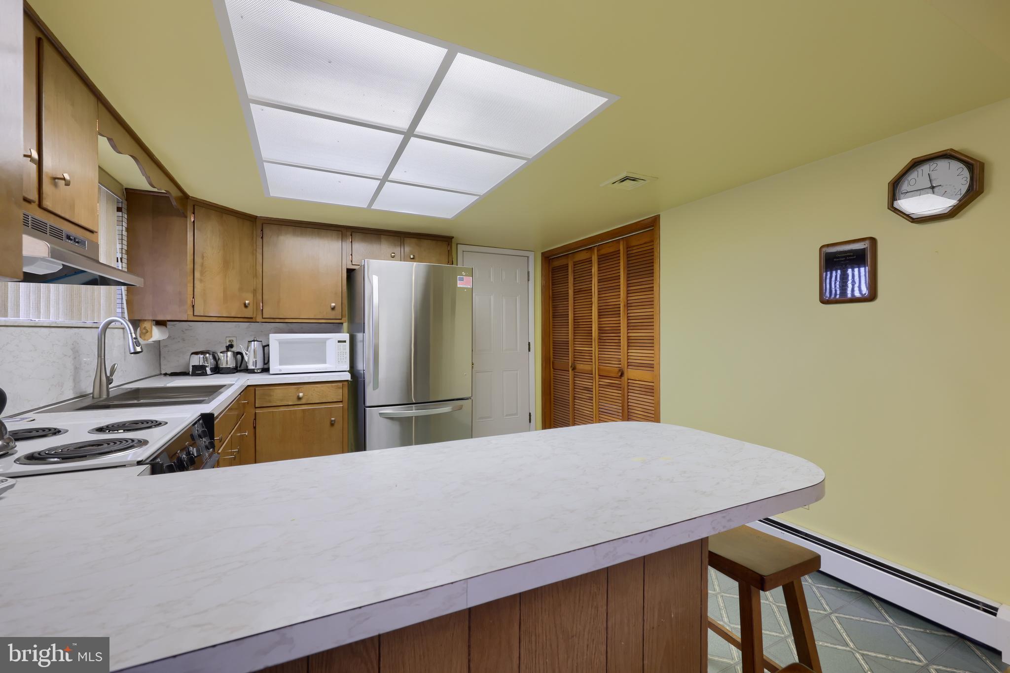 3916 Grant Street Reading, PA 19606 - Photo 22 of 39 a kitchen with stainless steel appliances a stove a refrigerator a sink dishwasher with a dining table and chair