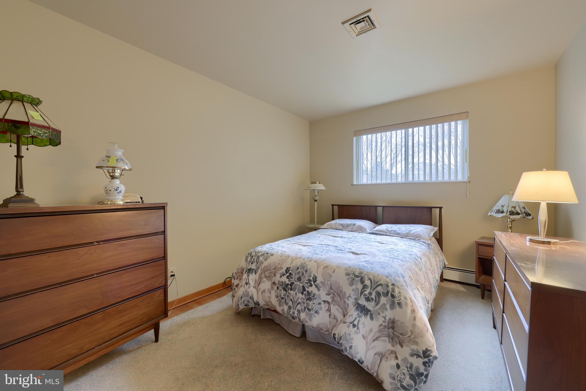 3916 Grant Street Reading, PA 19606 - Photo 29 of 39 a bedroom with a bed and a lamp on dresser