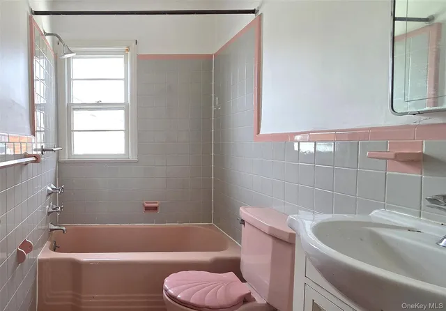 a bath tub sitting next to a white toilet and a sink