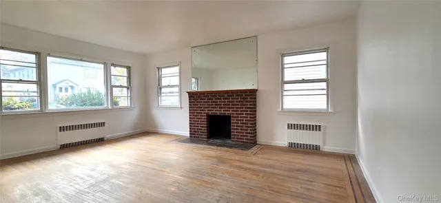 an empty room with windows and fireplace