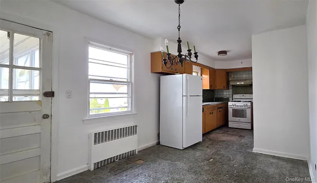 a view of a kitchen with a sink a refrigerator and window