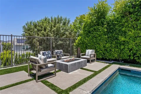 a view of a patio with couches table and chairs with wooden fence