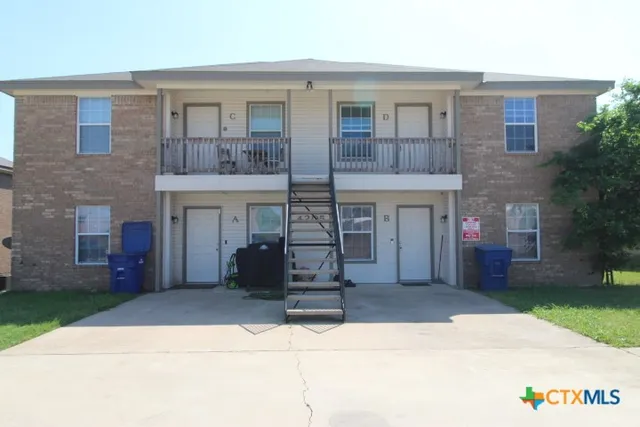 front view of a brick house with a yard