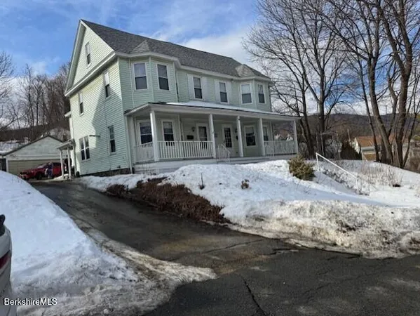 a front view of a house with a yard covered in snow