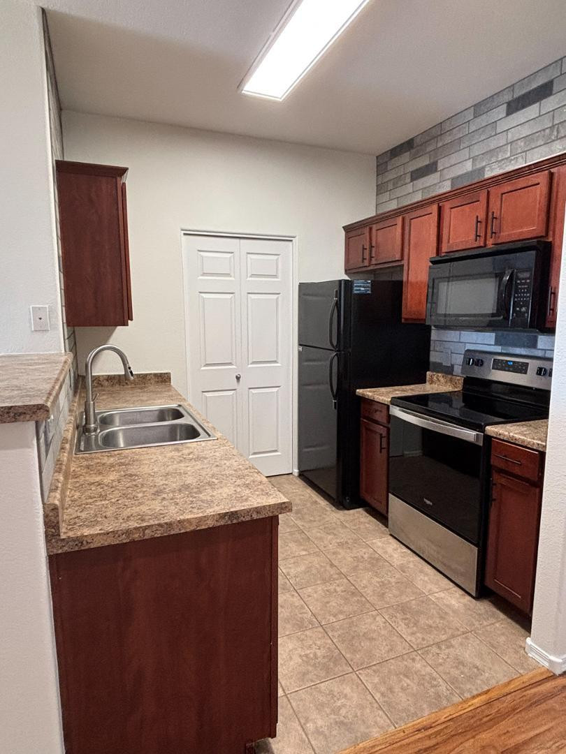 3302 North 7th Street, Unit 335 Phoenix, AZ 85014 - Photo 8 of 14 a kitchen with stainless steel appliances granite countertop a refrigerator stove and sink