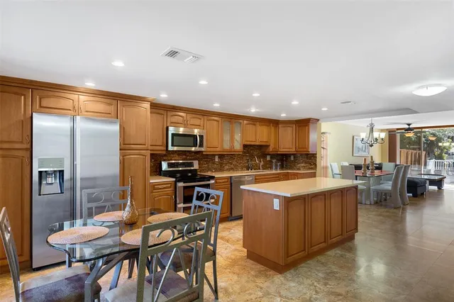a kitchen with a table chairs refrigerator and cabinets