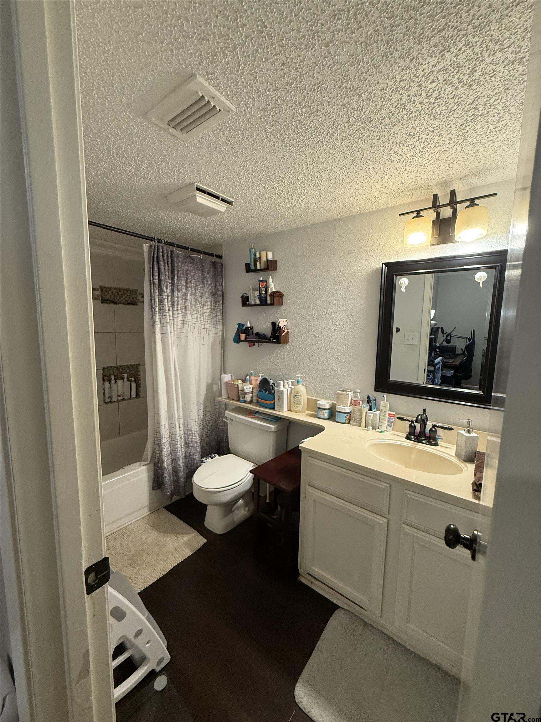 1740 Mill Creek Drive Tyler, TX 75703 - Photo 13 of 19 a bathroom with a toilet sink and mirror