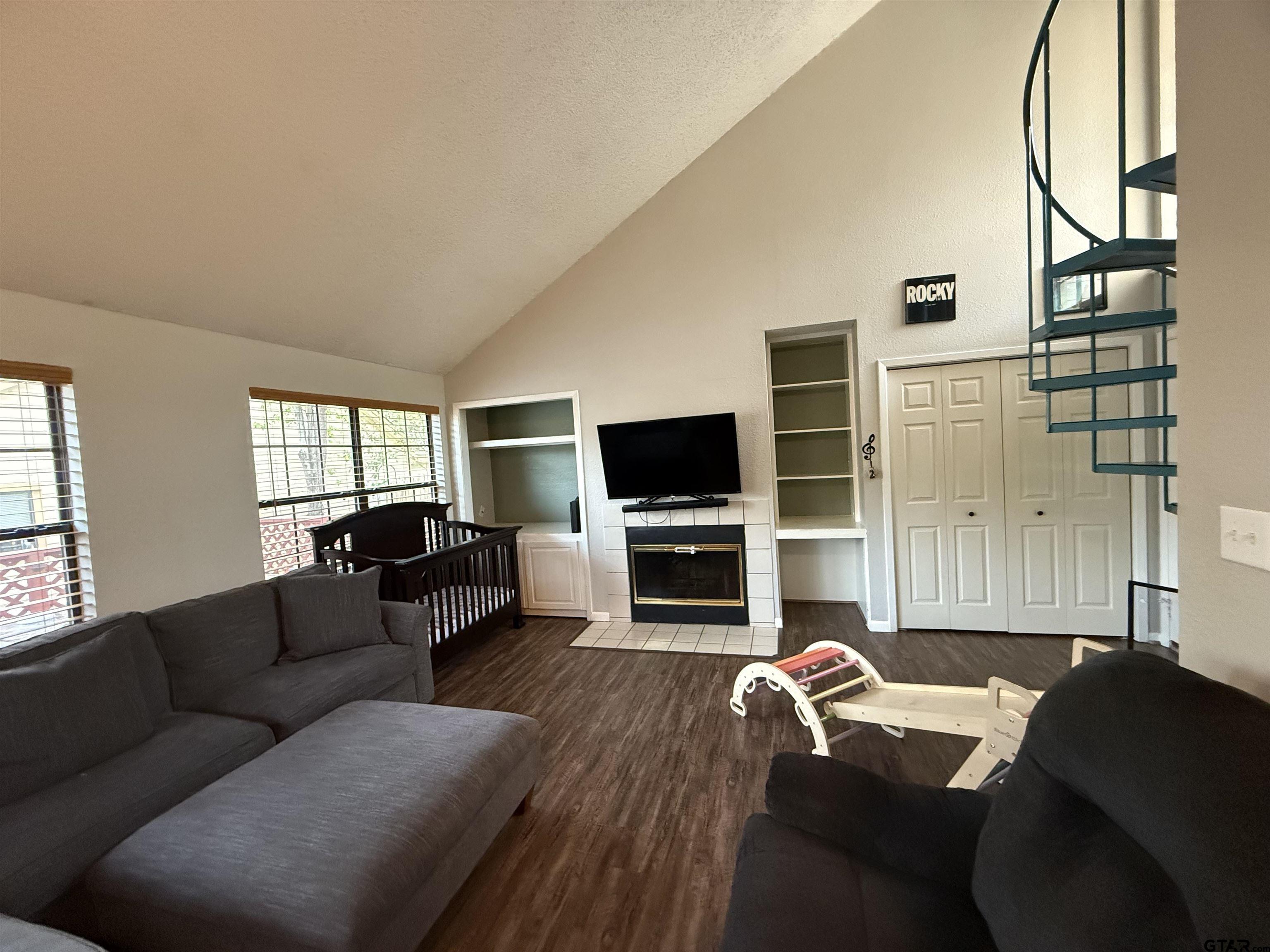 1740 Mill Creek Drive Tyler, TX 75703 - Photo 2 of 19 a living room with furniture a flat screen tv and a fireplace