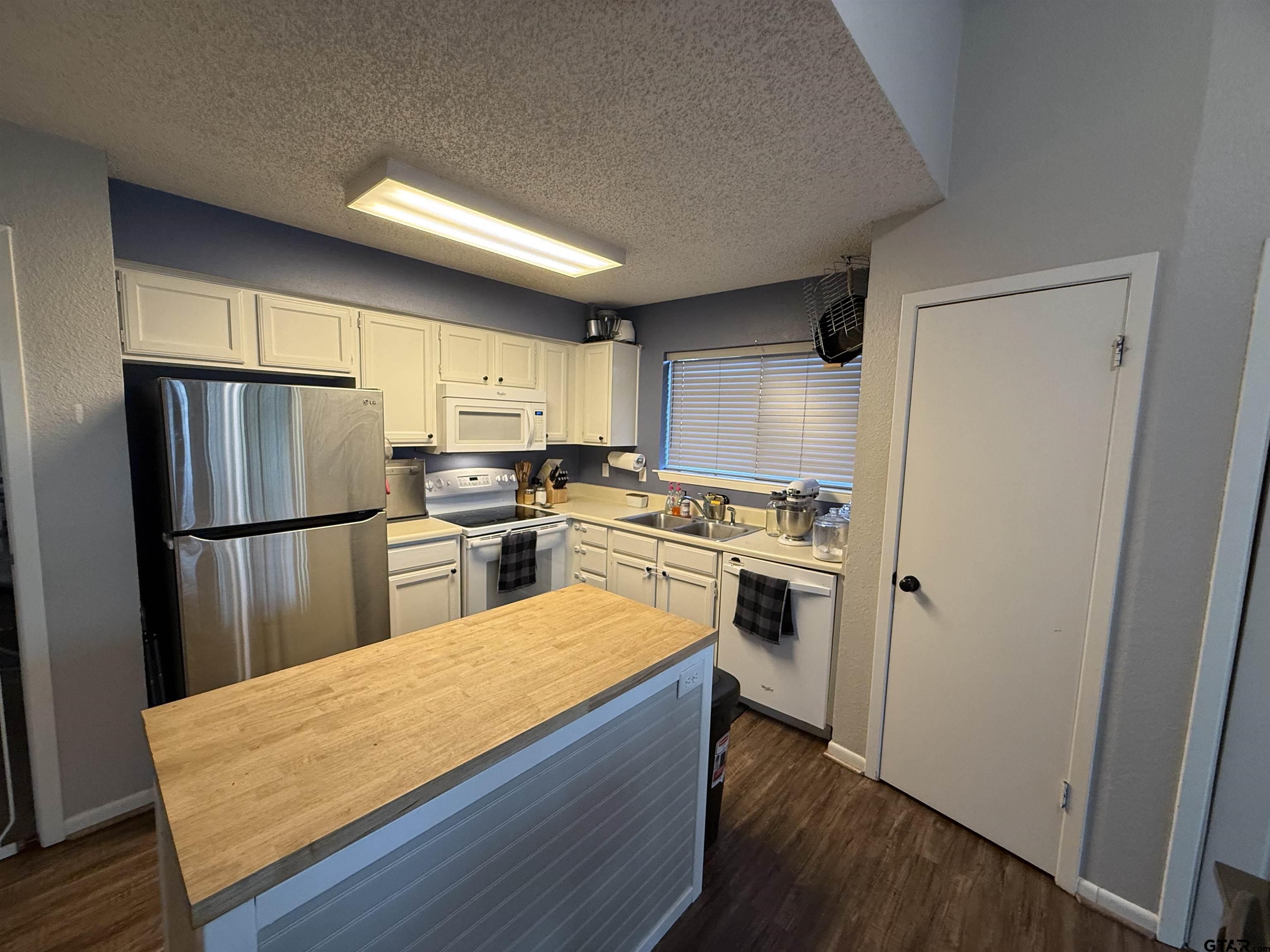1740 Mill Creek Drive Tyler, TX 75703 - Photo 4 of 19 a kitchen with white cabinets and stainless steel appliances