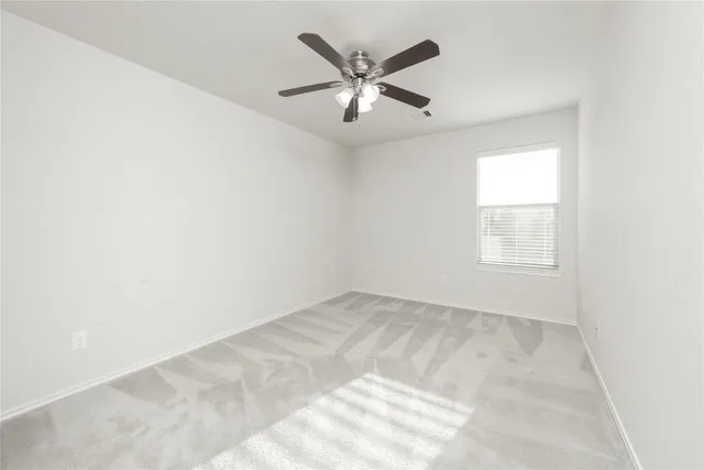 an empty room with chandelier fan