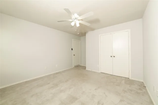 an empty room with a fan and a fan