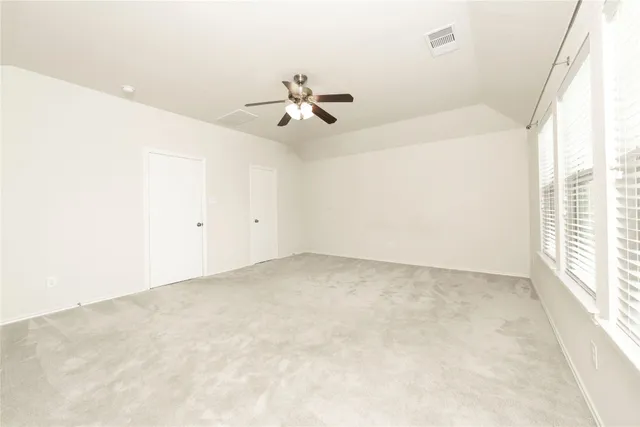 an empty room with a window and a fan