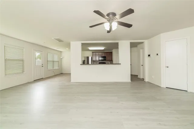 an empty room with chandelier and windows