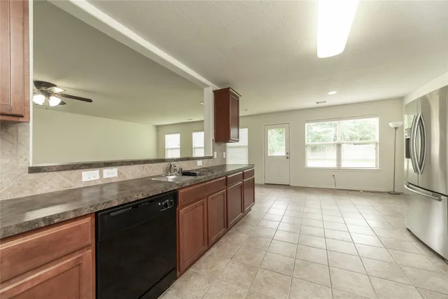 a large kitchen with granite countertop a sink and dishwasher a stove with wooden floor